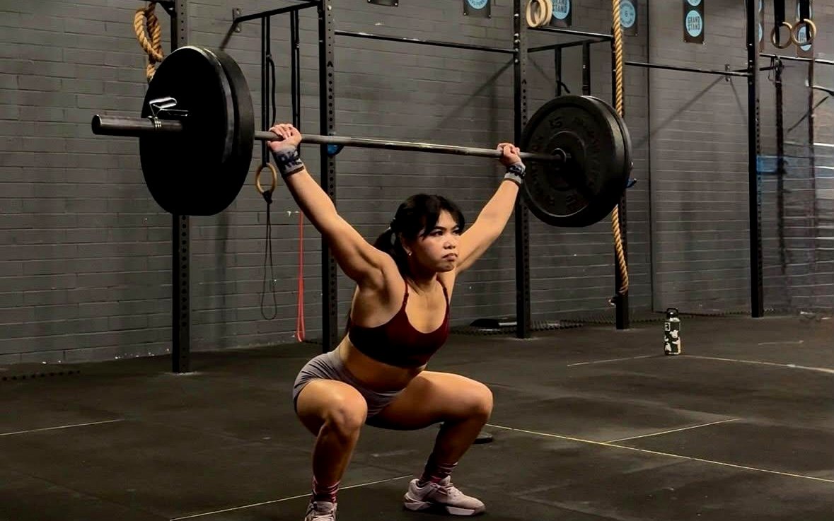 Athlete locking out a barbell overhead in a deep squat during Olympic weightlifting at Grandstand Perth